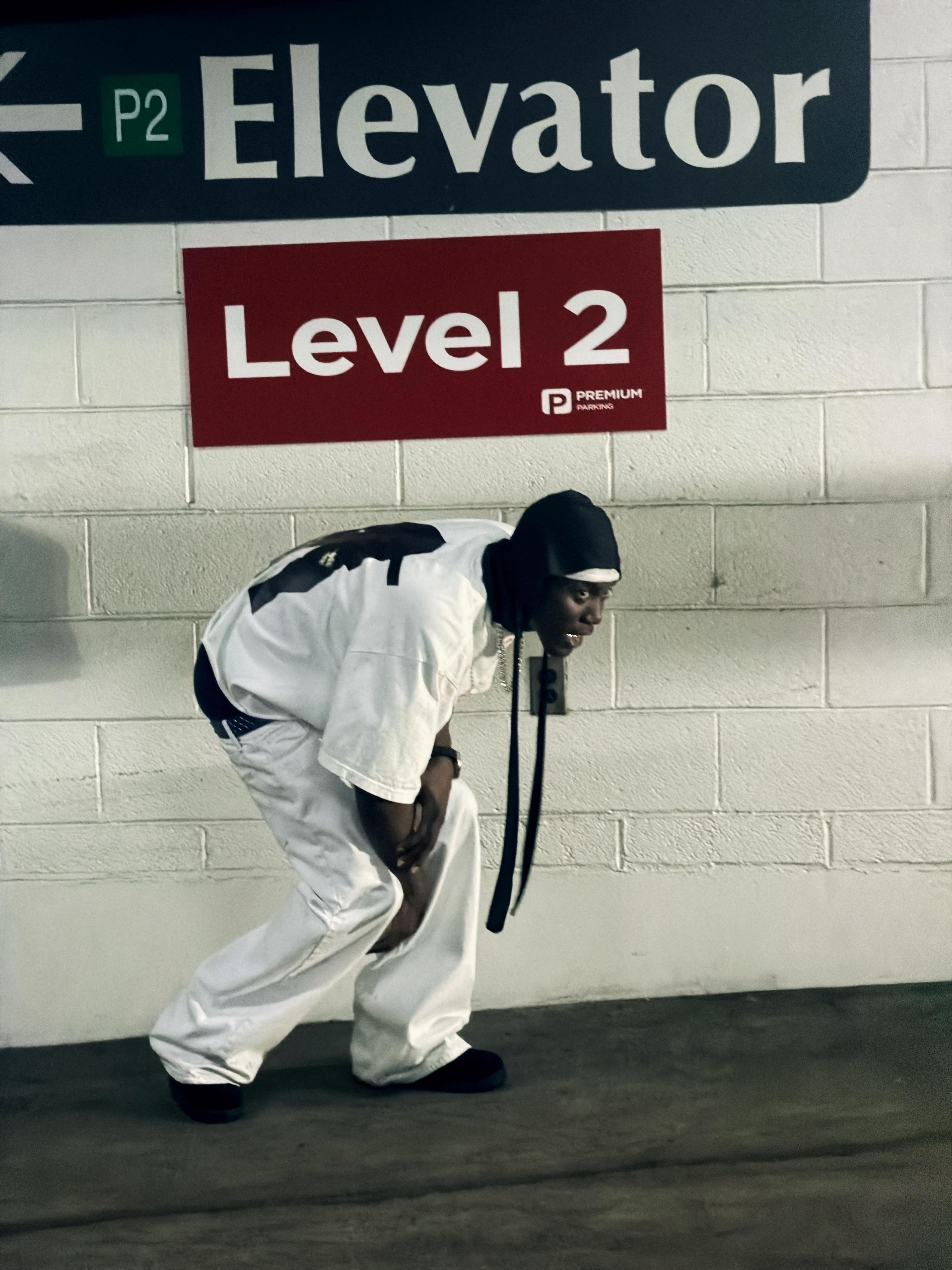 Tabby Blakes posing beneath an elevator Level 2 sign